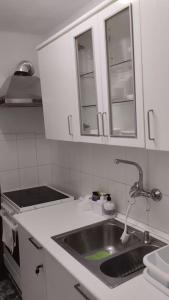 a kitchen with a sink and white cabinets at metro La Salut in Badalona