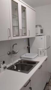 a white kitchen with a sink and a microwave at metro La Salut in Badalona