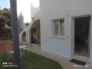 a white house with a patio and a table and chairs at Villa Confalonieri in Tricase