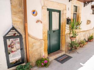 uma porta verde ao lado de um edifício com plantas em Il Ronco Del Principe em Augusta