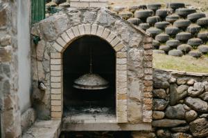 a stone oven with a bell in a building at Koliba TAMAN in Konjic