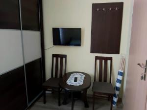隱海市的住宿－Morskie Oko，配有桌子和两把椅子以及电视的房间