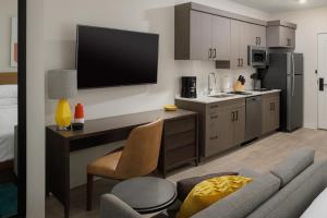 cocina con escritorio y TV en la pared en WaterWalk Jacksonville - Deerwood Park en Jacksonville