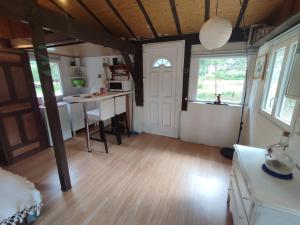 a kitchen and living room with a table and windows at La baraque des artistes in Laharie +4 photos