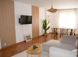 een woonkamer met een bank en een tafel bij Apartamento Deluxe Candeleda in Candeleda