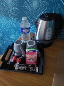 a tray with a coffee maker and a bottle of water at La grange d'Auguste in Jettingen