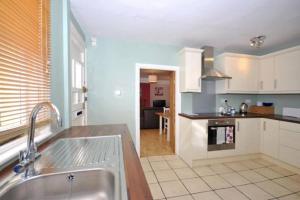 uma cozinha com um lavatório e uma bancada em Mews Cottage in Private Seafront Estate em Bognor Regis