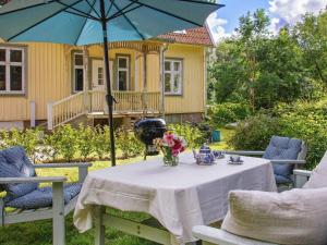 uma mesa com um guarda-chuva azul em frente a uma casa em Holiday home FÄRGELANDA V em Färgelanda