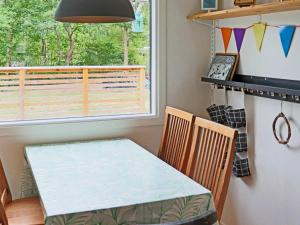 a dining room with a table and chairs and a window at Holiday home STENINGE in Steninge