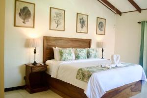 1 dormitorio con 1 cama grande y 2 lámparas en Hotel Playa Espadilla & Gardens en Manuel Antonio