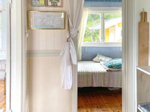 une porte menant à une chambre avec un lit et une fenêtre. dans l'établissement Holiday home KOLMÅRDEN, à Kolmården