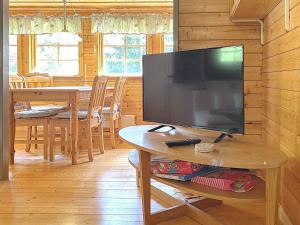 een woonkamer met een televisie en een tafel met een tafel bij Holiday home Rejmyre III in Rejmyre