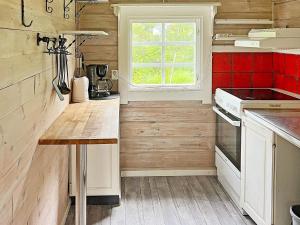 Holiday home ÅKERSBERGA V في اكيرسبيرغا: مطبخ بجدران خشبية وقمة منضدة خشبية