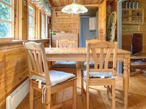 een eetkamer met een houten tafel en stoelen bij Holiday home Rejmyre III in Rejmyre