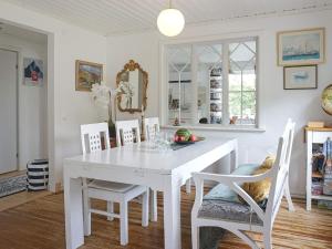 un comedor blanco con una mesa y sillas blancas en Holiday home Brastad XX, en Brastad