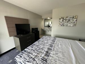 馬斯科吉的住宿－Budget Inn Muskogee，一间卧室配有一张床和一台平面电视
