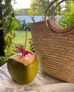 a coconut with a stick in it next to a purse at chillax Thoddoo in Thoddoo