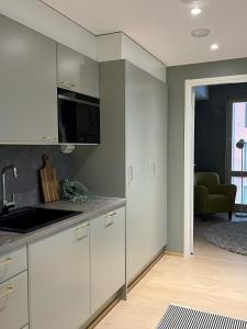 于韋斯屈萊的住宿－Tikka Apartments，一间带白色橱柜的厨房和一间客厅