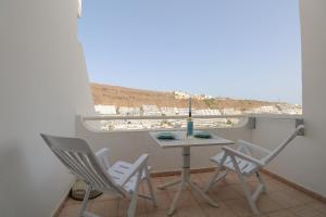 a small table and chairs on a balcony with a view at Relaxing Apartment with Ocean Views in Puerto Rico de Gran Canaria