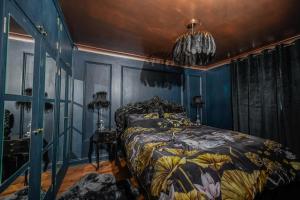 a bedroom with blue walls and a bed with a floral bedspread at South coast boudoir in Bognor Regis