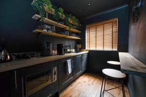 a kitchen with a counter and two stools in it at South coast boudoir in Bognor Regis