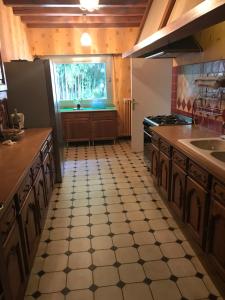 a kitchen with a tile floor and a window at Le Moulin de Crampaux in Mansigné