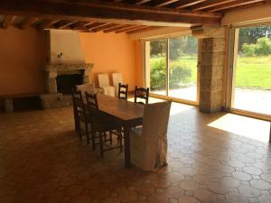 a dining room with a table and chairs and a fireplace at Le Moulin de Crampaux in Mansigné