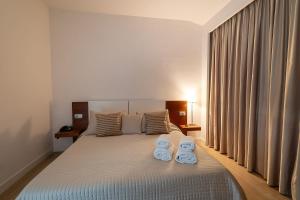 una camera da letto con un letto e due asciugamani di Villa dei Tigli Resort & SPA a Pietrelcina
