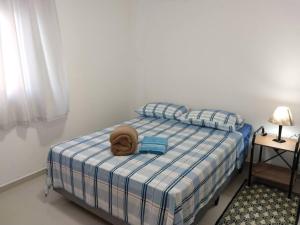 a bedroom with a bed with a hat on it at Lindo Apartamento na Praia do Sonho in Itanhaém