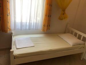 uma pequena cama num quarto com uma janela em Nafija No1 em Donji Stoj