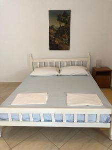 uma cama num quarto com uma cama branca em Nafija No1 em Donji Stoj