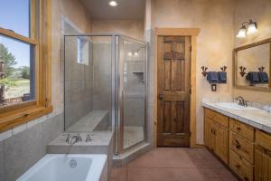 een badkamer met een douche, een bad en een wastafel bij Coyote Run #2 - Stunning Views in Moab