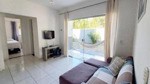 sala de estar con sofá y ventana grande en Casa com 4 quartos, piscina e área gourmet, en Porto Seguro