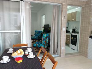 una sala da pranzo con tavolo e sedie e una cucina di Lindo Apartamento na Praia do Sonho a Itanhaém