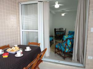 uma sala de jantar com uma mesa e cadeiras e uma janela em Lindo Apartamento na Praia do Sonho em Itanhaém