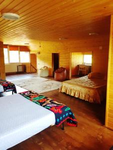 a bedroom with two beds in a wooden cabin at Casa Eby in Vidolm