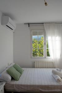 een witte slaapkamer met een bed en een raam bij Apartamento Deluxe Candeleda in Candeleda