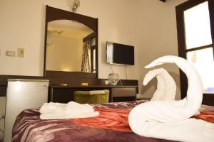 Mashrabiya Hotel في الغردقة: غرفة فندقية ذات ديكور بجعة على سرير