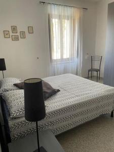 ein Schlafzimmer mit einem Bett, einem Fenster und einem Stuhl in der Unterkunft La Vecchia Chiassaia (mare/montagna) in La Pescaia
