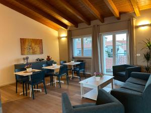 un restaurante con mesas y sillas y una habitación con ventanas en Ferdinando’s House, en Pozzomaggiore