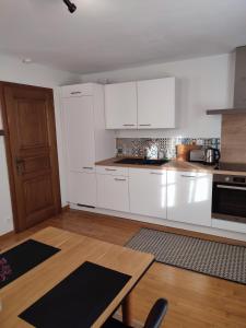 Una cocina con gabinetes blancos y una mesa de madera. en Confortable appartement au centre de Sélestat, en Sélestat