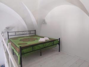 een slaapkamer met een bed met een groene tafel bij La dimora dei nonni in Tuglie