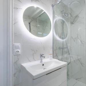 Baño blanco con lavabo y espejo en Mat&Ness Appartment en Beauvais