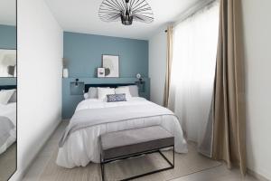 1 dormitorio con cama y pared azul en Mat&Ness Appartment en Beauvais