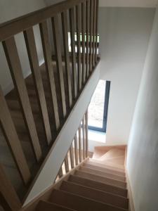eine Treppe in einem Haus mit Holzgeländer in der Unterkunft Gîte de Bel Oeuvre 