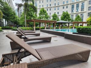 マニラにある81 Newport C5 10i Balcony & Pool across NAIA T3の籐の椅子とスイミングプール