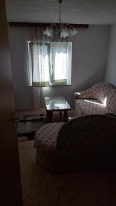un soggiorno con divano, tavolo e finestra di Apartman Mely a Kulen Vakuf