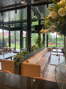 un restaurante con sofás, mesas y flores en Santa Villa & restaurant en Sremska Mitrovica