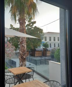 a patio with a table and chairs and a palm tree at Nilus Boutique Hotel in Urla