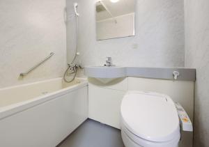 a white bathroom with a toilet and a sink at APA Hotel Osaka Tanimachi Yonchome-Ekimae in Osaka